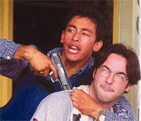 An armed robber holds a gun at newspaper photographer Martin Firpo inside a gas station while negotiating his escape with the police at Rodriguez village, 70 km from Buenos Aires, on Wednesday 