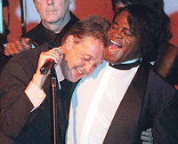 Paul McCartney (left) leans on James Brown's shoulder during the grand finale of the 31st Annual Songwriter's Hall of Fame Induction and Awards dinner in New York, on Thursday