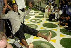 Brazilian soccer star Pele shows off his feet before places his footprints in wet cement during festivities for the 50th anniversary of the Maracana Stadium in Rio de Janeiro, Brazil, on Friday