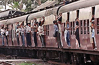 Central Railway commuters hang out of railway cars on their way downtown, as train drivers drove at a snails pace on Monday. The work-to-rule action caused railway traffic snares and the overcrowding of most trains.