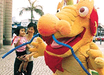 A girl greets "Ah Lung", a mascot for Hong Kong's bid to host the 2006 Asian Games June 19