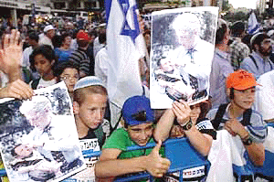 Israeli youths show photographers posters of Clinton cradling Ehud Barak during a rally where thousands of right-wing settlers protested against Israeli goverment plans to hand back vast sections of the West Bank to Palestinian control in front of Israeli Prime Minister Ehud Barak's official residence in Jerusalem Monday June 19, 2000. The protest follows reports that Barak plans to give Palestinians over 90 percent of the West Bank territory, dismantling Jewish settlements in the area handed over, or leaving them under Palestinian rule