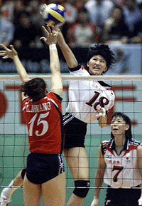 apanese volleyball player Sachiko Sugiyama (C) spikes the ball over Chinese player Wang Lina (L) during a game of the women's volleyball final qualifying round for the Sydney Olympic games at the Tokyo Metropolitan Gymnasium, on Wednesday. Japan and China finished 1-1 after two sets of the five sets game.