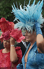 Two women hold on to their hats to stop them from blowing off in the wind at Ascot, 30 miles west of London, on Thursday. Spectators have come to watch the horse races on Ladies Day, the third day of races at Ascot.