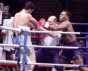 Lou Savarese (Left) is shielded by the referee from Mike Tyson during their non-title heavyweight fight at Hampden Park in Glasgow, Scotland on Saturday
