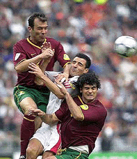 Portugal's Jorge Costa, left, and Fernando Couto, (right) challenge a high ball with Turkey's Havutcu Tayfun during a quarter final of the EURO 2000 soccer championships between Portugal and Turkey at the Arena Stadium in Amsterdam Saturday