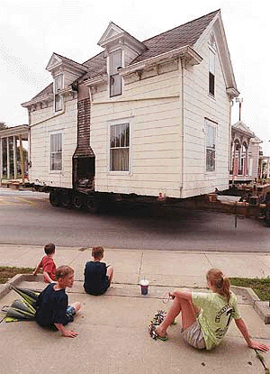 Joel Dunham, 5, from left, Jacob Dunham, 9, Joshua Dunham, 9, and Megan Dunham, 11, look on as a historic home is moved to a new location in downtown Bedford, Ind. on Tuesday