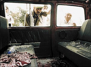 A policeman examines a vehicle damaged in a grenade explosion in Srinagar on Wednesday.