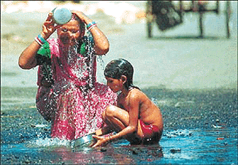 Slum-dwellers Laxmi Devi and her daughter Rumia use water from a pot hole for their daily ablutions 02 July 2000. Scarcity of clean water is still a major problem for many of Calcutta's millions of inhabitants