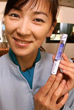 An employee of Japan's mobile telecommunication giant NTT DoCoMo displays the prototype of a pen-shaped mobile phone at the company's showroom in Tokyo 06 July 2000. NTT DoCoMo will start operation of the next generation of mobile phone system