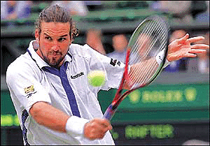 Pat Rafter of Australia plays a backhand return against Andre Agassi of the US during their semi-final match at the Wimbledon Tennis Championships, on Friday