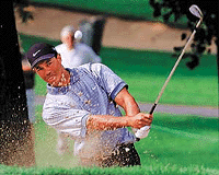 Tiger Woods hits out of the sand onto the 11th green during the first round of the 2000 Advil Western Open at the Cog Hill Golf and Country Club in the Chicago suburb of Lemont, on Thursday