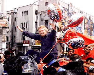 Virgin Atlantic Airways Chairman Sir Richard Branson posing for the photographers sitting atop an auto rickshaw at Connaught Place in New Delhi