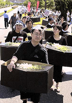  FUKUOKA : Protesters, carrying mock small coffins, symbolizing the death of poor African children, march near the venue of the meeting by finance ministers from the Group of Seven industrialized nations in Fukuoka, southern Japan, Saturday, July 8, 2000. The protesters urged the industrialized nations to drop the international debts of the most impoverished countries. AP/PTI