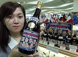 Liquor store clerk Chie Oyakawa holds a bottle of �Okinawa Summit 2000 Awamori,� a local liquor of the southern Japanese island of Okinawa, which is on display at Naha Airport on Friday. The local drink Awamori is made from rice and the commemorative bottles have been emblazoned with drawings of the leaders of the Group of Eight nations. � Reuters