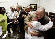 Plantiff Ralph Della Vecchia, right, who's wife Angie died of cancer, hugs Margaret Amodeo, wife of plantiff Frank Amodeo, after the jury returned a verdict in the punitive phase of the Florida smokers trial on July 14 in Miami.