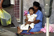 An ethnic Fijian Indian mother and daughter beg on the streets of Suva, Fiji, on Saturday.