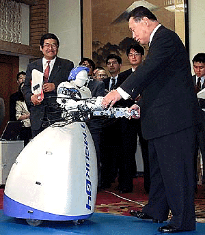 Japanese Prime Minister Yoshiro Mori, right, dances with "Tmsuk 04," a remote-controlled robot, in a joke at his official residence in Tokyo on Tuesday. Tokyo Institute of Technology, Sony, NEC and Tmsuk demonstrate their five robots to show Japan's leading technologies to Mori. � AP/PTI photo
