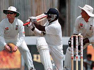 Sri Lankan captain Sanath Jayasuriya sweeps the ball for four runs as South African wicket keeper Mark Boucher (R) and Darrel Cullinon look on during the first day of the first test cricket match between Sri Lanka and South Africa in Galle International cricket ground on Thursday