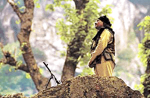An Indian paramilitary personnel stands guard over a trail used by pilgrims during the annual trek to the Amarnath cave on Thursday