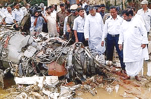 Indian Minister of Civil Aviation Sharad Yadav (R) looks at the remains of an engine as he visits the site of the 17 July Alliance Air Boeing 737-200 crash in Patna, 21 July 2000. A team of Boeing officials have joined Indian aviation experts investigating the crash that killed 55 people, as the cause has yet to be determined. Civil aviation authorities put the blame on pilot error. Alliance Air is a subsidiary of Indian Airlines. AFP poto