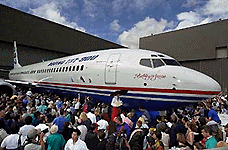 Around 7,000 Boeing and Alaska Airlines employees and their families swarm a new Boeing 737-900 after its rollout at the Boeing Commercial plant in Renton, Wash.