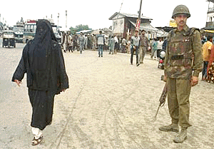 A Kashmiri Muslim woman walks past as an Indian para-military trooper standing guard in Srinagar, the summer capital of Jammu and Kashmir in India on Tuesday. The news of ceasefire by the frontline Hizbul Mujahideen militant group came as a surprise for residents in Kashmir. It is hoped the ceasefire can lead to a peaceful solution and will end the decade old rebellion in the Himalyan region which has claimed more than 30,000 lives