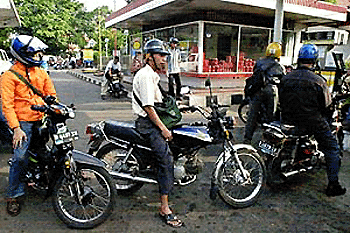 Motorcycle riders wait in line to fill their tanks with premium fuel at a gas station in Jakarta, 26 July 2000.  Malaysia, Singapore and Thailand have all agreed to export premium-grade gasoline to Indonesia to help it cop with a domestic fuel shortage.  AFP PHOTO/Weda