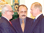 President Vladimir Putin, right, greets Iraqi Deputy Prime Minster Tariq Aziz during their meeting at the Kremlin in Moscow on Wednesday.  Tariq Aziz lasahed out against the United States on Wednesday, saying that U.S.-backed effort to prosecute Iraqi leaders on war crimes charges was "blackmail." In center is an interpreter
