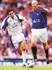 Rangers German striker Jorg Albertz (R) holds of St Johnstone's midfielder Nick Dasovic in their Scottish premier division match at Ibrox stadium in Glasgow on Saturday