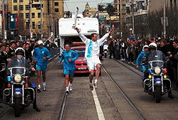 Sam Patten (C) shows his excitement as he runs through the streets of South Yarra, Melbourne with the Sydney 2000 Olympic Torch on Monday. The Olympic Torch is spending 100 days travelling around Australia on it's way to Sydney for the opening ceremony of the Sydney 2000 Olympic Games on 15 September