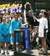 Australian Phoebe Knowles exchanges the Olympic flame at Melbourne Town Hall in front of tens of thousands of people in Melbourne, Victoria, on Monday