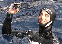 Apnea free-diver Pierre Frolla, of Monaco, shows his metal plate, the evidence he established the new free-diving World record after reaching a dephth of 73 meters (79.8 yards) in the Monaco's territorial waters, on Thursday
