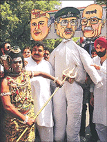A man dressed as Hindu Lord Shiva (L) hits an effigy of the Pakistani military ruler General Pervez Musharraf with a trident during a protest in New Delhi on Saturday. The activists were protesting against a recent series of guerrilla attacks across Jammu and Kashmir state which left at least 90 people dead, including 22 Hindu pilgrims