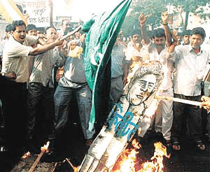Congress activists burn an effigy of US President Bill Clinton and wave a Pakistani flag before setting it on fire during a demonstration against violence in Kashmir in front of the American Center in Calcutta on Monday