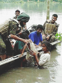 Assam: Jawans of 18 Sikh Regiment busy saving the life of a girl child near Rangiya sub division under Kamrup district during recent floods in Assam as road communication is submerged under water due to floods