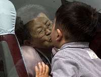 South Korean Og-im (74) grandmother, kisses her grandson goodbye on a bus prior to her departure for the airport from a hotel in Seoul on Tuesday