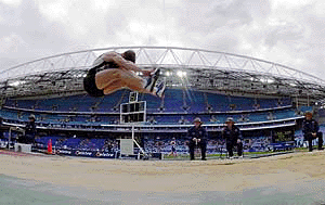 A competitor in the mens decathlon long jump flys through the air during the Australian selection trials at Stadium Australia, the main stadium for the Sydney Olympics, on Thursday