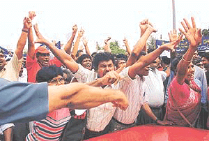 Pro-government supporters shout anti-Opposition party slogans at a rally in Colombo on Friday