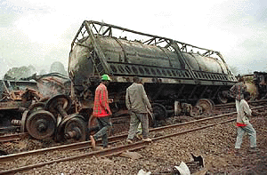 The wreckage of a train lies on side after the crash in which eighteen people were killed and dozens injured when a cargo train carrying three gas cylinders crashed into a parked goods train at a station south of Nairobi, early Sunday, Aug.20, 2000, causing an explosion which destroyed nearby houses. Most of the victims were residents of railway houses