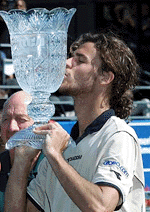 Gustavo Kuerten, of Brazil, kisses the trophy after winning the RCA Championships in Indianapolis, on Sunday