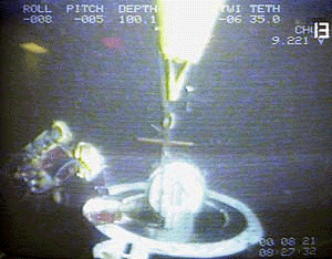 Norwegian divers open the hatch of the doomed Russian nuclear submarine ��Kursk�� in a still from video aboard the divers� ship MV Seaway Eagle on Monday. Norwegian divers said they believed all the 118 crewmen of the stricken submarine had died in an accident nine days ago after they penetrated the vessel and found it flooded