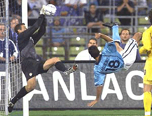 Leeds goalie Martyn Nigel ( left) stops the ball ahead of Munich's Italian player Paul Agostino during their Champions League qualification match TSV 1860 Munich vs. Leeds United at the Munich Olympic stadium on Wednesday