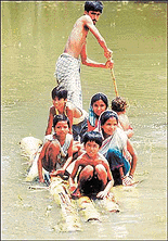 Villagers use banana trunks as a makshift raft during a flood in Hajo in the north eastern Indian state of Assam August 23, 2000. For the last few months, floods in India, Nepal and Bangladesh have killed hundreds of people and made millions homeless