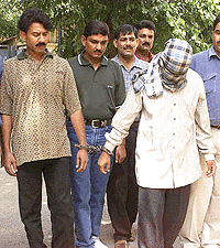 Ajit Tukaram Sawant (face covered), operation chief of the notorious Mumbai-based Chotta Shakeel gang and his city-based contact Shamsuddin (left) at a police custody in New Delhi on Friday, who were arrested by speical cell of Delhi police on Thursday