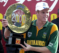 South African cricket captain Shaun Pollock poses wth the the trophy after his team defeated Pakistan in the Singapore Challenge 2000 cricket triangular final in Singapore on Sunday