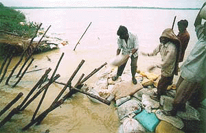 Workers build up embankments with sand bags 27 August 2000 after the Foxsagar reservoir in the flood ravaged southern Indian city of Hyderabad, developed a second breach after fresh rains. Around 131 people have already died in the worst floods in decades to ravage the Southern Indian state of Andhra Pradesh