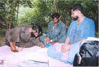 Chennai: Outlaw Veerappan poring over documents from Tamil Nadu and Karnataka regarding his demands for release of Kannada Star Rajkumar and other hostages in the jungles. Emissary R.R. Gopal, talking to the bandit for the third time and Veerappan's deputy Sethukuli Govindan are also seen