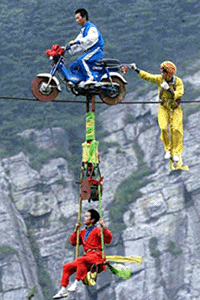 JIUJIANG, CHINA : Daredevils perform a highwire acrobat at Lushan Mountain, in China's Jiangxi province, on Saturday.