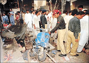 A Pakistani policeman removes a scooter after a bomb explosion in Dharampura bazaar in eastern Lahore, the provincial capital of Punjab September 7, 2000. At least three people were killed and 20 others wounded, police officials said